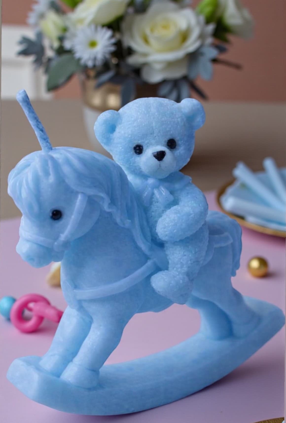 Sculpted teddy bear on rocking horse candle in pink and blue