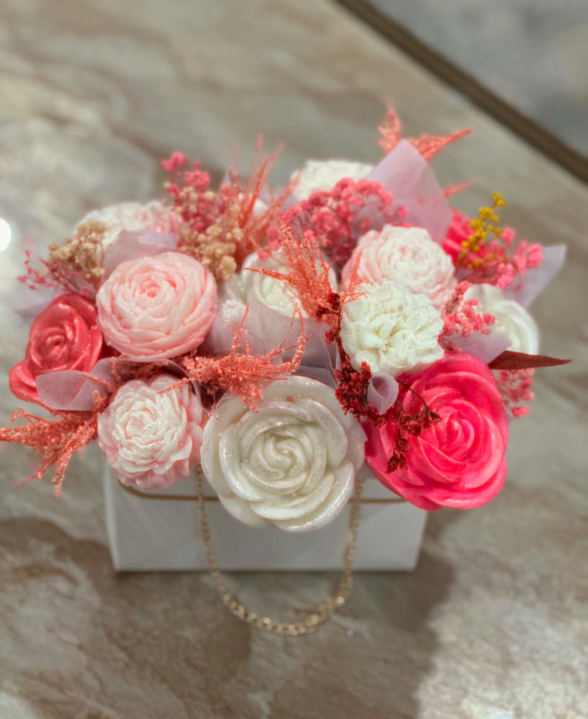 Coral and white sculpted rose candles arranged in a gift box